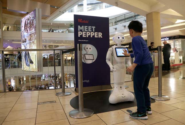 A boy plays with Pepper the robot at Westfield Mall in San Francisco on Dec. 22, 2016. 