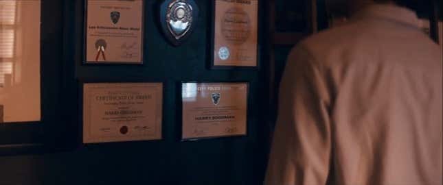 Tim is shown looking at his father's awards for doing cop things.