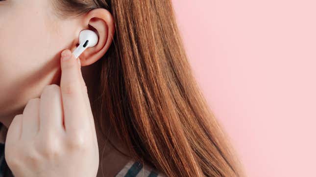 A woman places an AirPod Pro in her ear