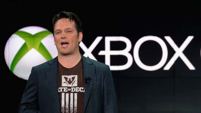 Phil Spencer stands in front of Xbox logo.