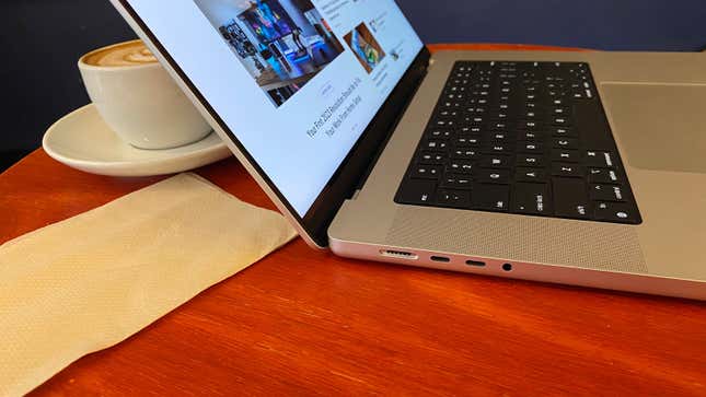 An M2-Powered MacBook Pro sitting on a table next to a napkin and coffee
