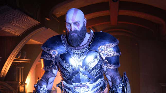 Kratos stands inside a dark cabin while covered in a blue light. 