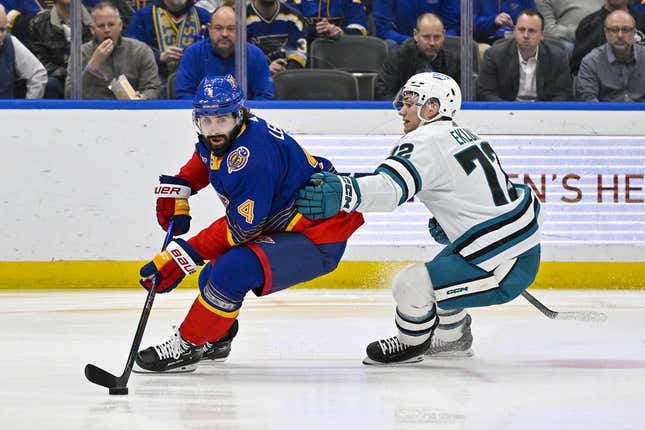 Mar 9, 2023; St. Louis, Missouri, USA;  St. Louis Blues defenseman Nick Leddy (4) controls the puck as San Jose Sharks left wing William Eklund (72) defends during the first period at Enterprise Center.
