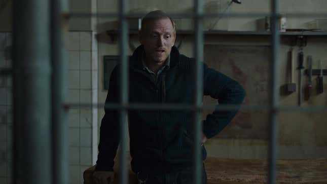 David is seen talking to someone from the outside of a cell with tools hanging on the wall behind him.
