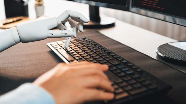 A person typing on a keyboard next to a monitor showing code and a robot hand also typing on the same keyboard.