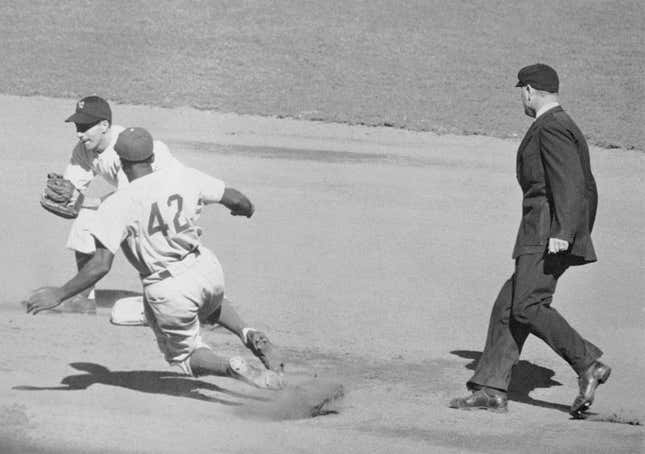 Jackie Robinson of the Brooklyn Dodgers, first Negro ever to play in a World Series, slides into second with stolen base in the first inning of opening game at Yankee Stadium.
