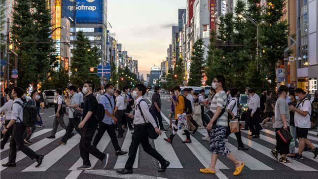 A crowd of people cross the street in Akihabara. 