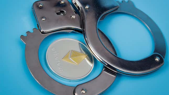 One ethereum coin and handcuffs over blue background.