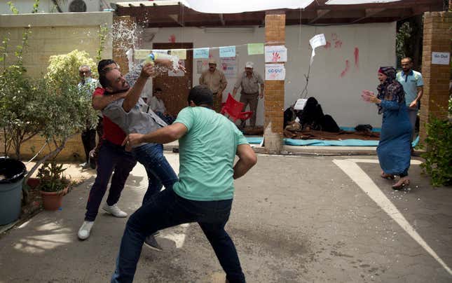 Bystanders prevent a UNRWA employee from setting himself alight, July 25, 2018.