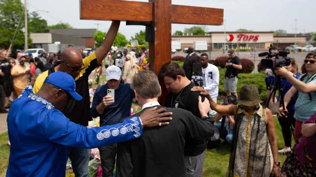 A group prays at the site of a memorial for the victims of the Buffalo supermarket shooting outside the Tops Friendly Market on May 21, 2022, in Buffalo, N.Y. 