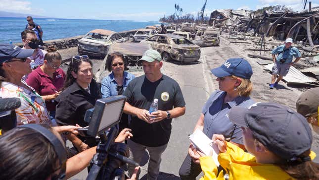 FILE - Hawaii Gov. Josh Green, center, speaks to reporters during a tour of wildfire damage in Lahaina, Hawaii, Aug. 12, 2023. Green said Thursday, Aug. 31, 2023, that his administration has opened several investigations into people who have allegedly made unsolicited offers for property in the fire-stricken Maui town of Lahaina in violation of a new emergency order. (AP Photo/Rick Bowmer)
