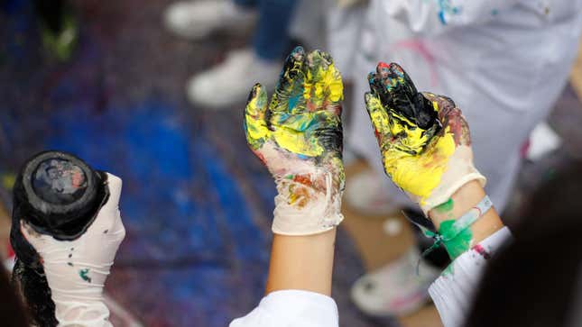 A photo of someones hands all covered in paint. 