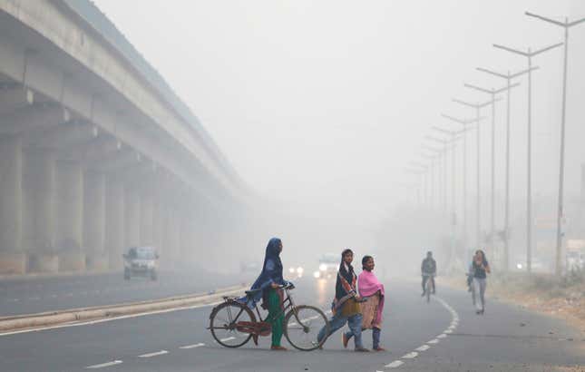 People cross the road in Delhi