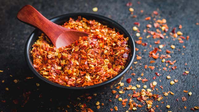 A bowl of chili flakes on a table.