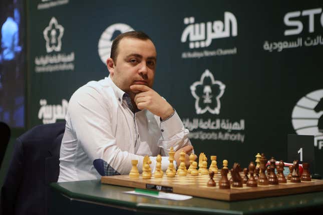 Tigran Petrosian sitting in front of a chess board.