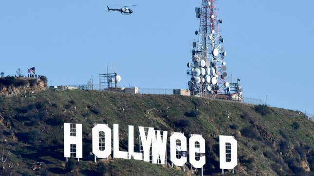 A police helicopter flies over the Hollywood sign after somebody improved it. 