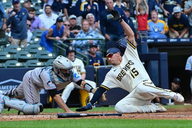 Sep 14, 2023; Milwaukee, Wisconsin, USA; Milwaukee Brewers left fielder Tyrone Taylor (15) scores past Miami Marlins catcher Jacob Stallings (58) in the fifth inning at American Family Field.