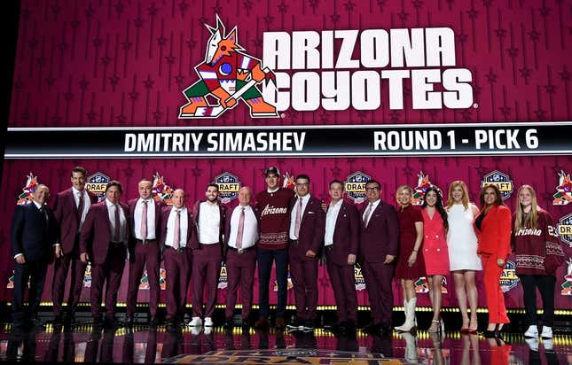 Jun 28, 2023; Nashville, Tennessee, USA; Arizona Coyotes draft pick Dmitriy Simashev stands with Coyotes staff after being selected with the sixth pick in round one of the 2023 NHL Draft at Bridgestone Arena.