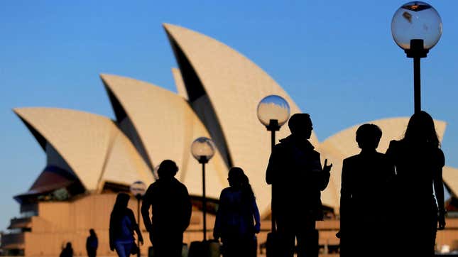 People are silhouetted against the Sydney Opera House at sunset in Australia, November 2, 2016.