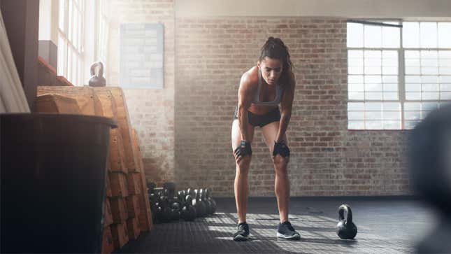 woman looking exhausted next to a kettlebell