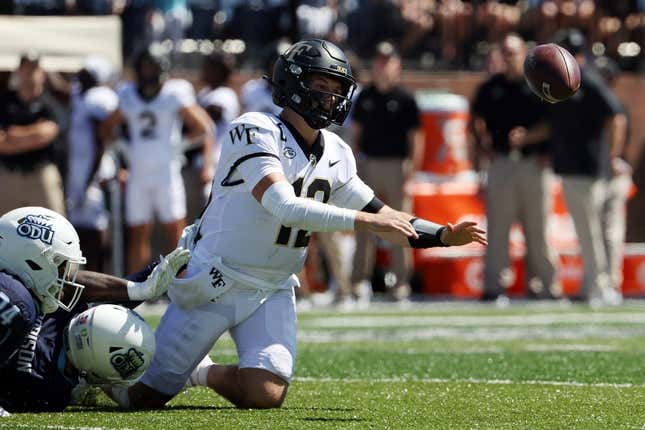 Sep 16, 2023; Norfolk, Virginia, USA; Wake Forest Demon Deacons quarterback Mitch Griffis (12) fumbles the ball while being tackled by Old Dominion Monarchs defensive end Amorie Morrison (4) and linebacker EJ Green (24) during the second quarter at Kornblau Field at S.B. Ballard Stadium.