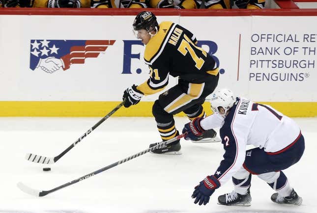 Dec 6, 2022; Pittsburgh, Pennsylvania, USA;  Pittsburgh Penguins center Evgeni Malkin (71) skates with the puck against Columbus Blue Jackets center Sean Kuraly (7) during the second period at PPG Paints Arena.