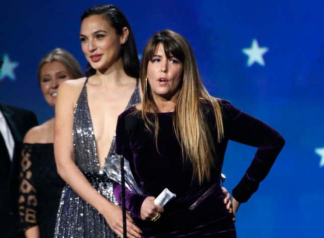 Director Patty Jenkins (C) accepts an award and delivers a speech, with actor Gal Gadot standing in the background (L)