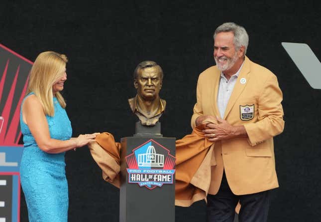 Aug 5, 2023; Canton, OH, USA; Dan Fouts and Mindy Coryell Lewis unveil the bust of San Diego Chargers and St. Louis Cardinals former coach Don Coryell (deceased) during the 2023 Pro Football Hall of Fame Enshrinement at Tom Benson Hall of Fame Stadium.