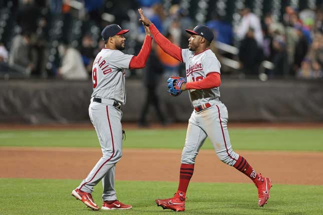 Apr 25, 2023; New York City, New York, USA;  Washington Nationals third baseman Jeimer Candelario (9) and center fielder Victor Robles (16) high five after the game against the New York Mets at Citi Field.