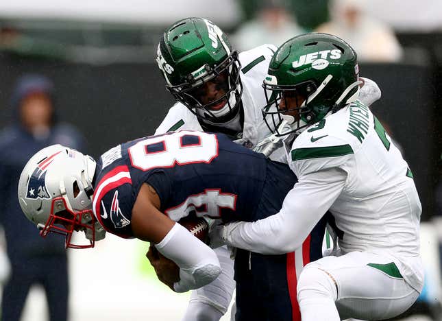 EAST RUTHERFORD, NEW JERSEY - SEPTEMBER 24: Kendrick Bourne #84 of the New England Patriots carries the ball as Jordan Whitehead #3 and Sauce Gardner #1 of the New York Jets defend in the first half at MetLife Stadium on September 24, 2023 in East Rutherford, New Jersey. (Photo by Elsa/Getty Images)