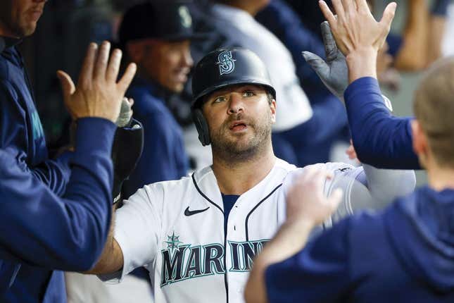 Jun 13, 2023; Seattle, Washington, USA; Seattle Mariners designated hitter Mike Ford (20) high-fives teammates in the dugout after scoring a run against the Miami Marlins during the sixth inning at T-Mobile Park.