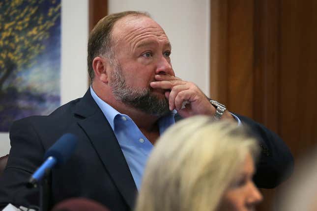 Alex Jones attempts to answer questions about his text messages asked by Mark Bankston, lawyer for Neil Heslin and Scarlett Lewis, during trial at the Travis County Courthouse in Austin, Wednesday Aug. 3, 2022. Jones testified Wednesday that he now understands it was irresponsible of him to declare the Sandy Hook Elementary School massacre a hoax and that he now believes it was “100% real.”