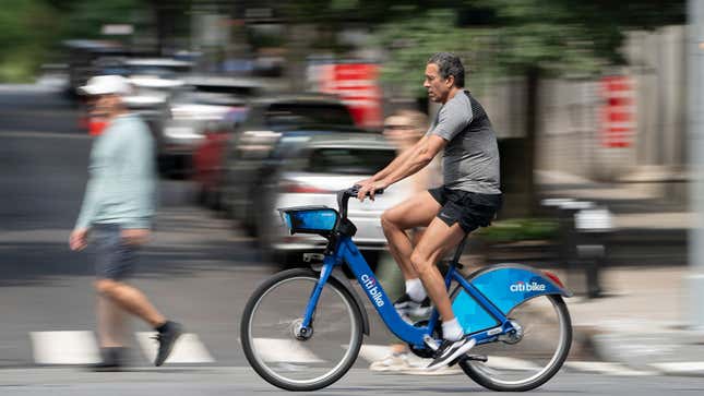 A photo of a man riding a Citibike in New York. 