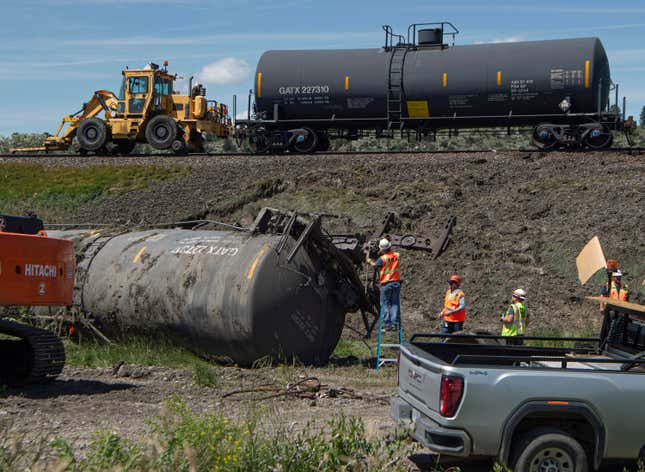 Crew members work on derailed cars at the site of a railroad bridge collapse on the Yellowstone River near Reed Point on Sunday, June 25, 2023, in Columbus, Montana. 