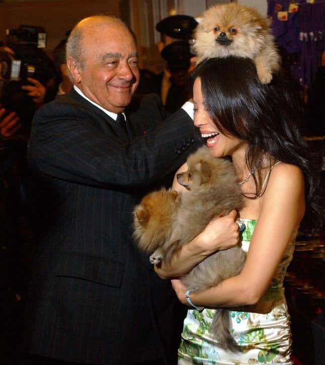 FILE - American actress Lucy Liu joking with Mohamed Al Fayed as she holds two Pomeranian puppies priced £999.00 each, as she officially opened the Harrods January Sale, in London, on Jan. 3, 2005. Al Fayed, the former Harrods owner whose son Dodi was killed in a car crash with Princess Diana, has died at age 94. His death was announced Friday, Sept. 1, 2023, by Fulham Football Club, which Al Fayed once owned. (Andy Butterton/PA via AP, File)