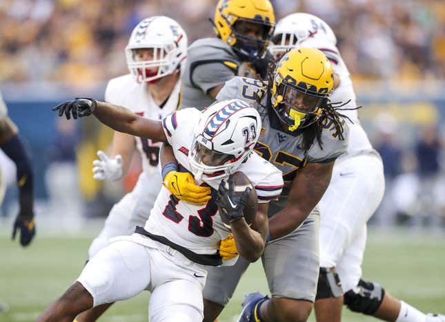 Sep 9, 2023; Morgantown, West Virginia, USA; West Virginia Mountaineers defensive lineman Mike Lockhart (93) tackles Duquesne Dukes running back JaMario Clements (23) during the second quarter at Mountaineer Field at Milan Puskar Stadium.