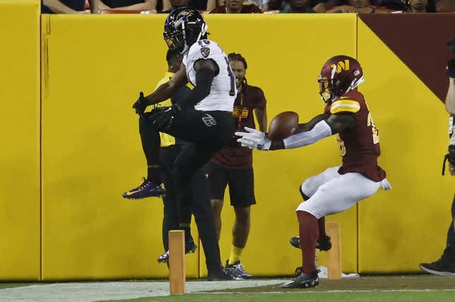 Aug 21, 2023; Landover, Maryland, USA; Washington Commanders safety Jartavius Martin (20) intercepts a pass intended for Baltimore Ravens wide receiver James Proche II (10) during the second quarter at FedExField.