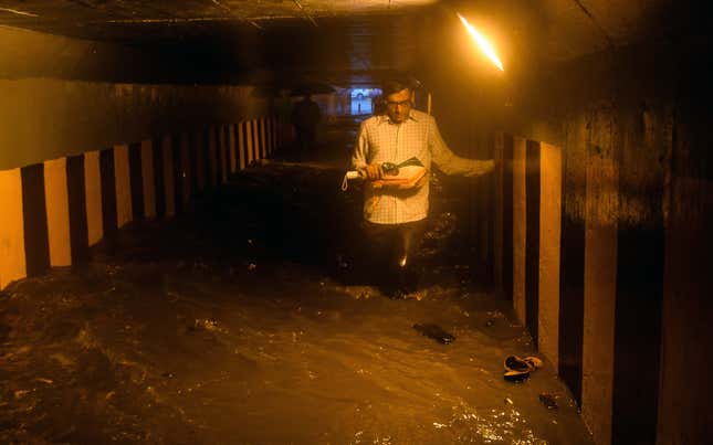 A man walks through a waterlogged subway, at Andheri, on June 28, 2019 in Mumbai, India. 