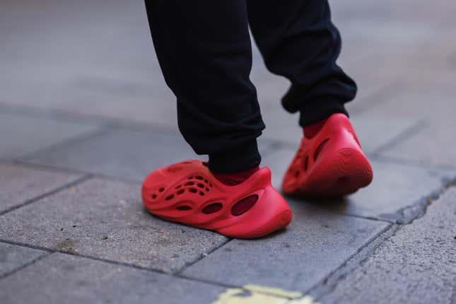LONDON, ENGLAND - SEPTEMBER 17: A fashion week guest seen wearing red adidas yeezy shoes, outside paul and joe during London Fashion Week September 2022 on September 17, 2022 in London, England.