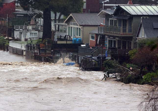 Yards along Soquel Creek in Capitola Village are flooded by storm surge on Thursday, Jan. 5, 2023, in Capitola, California.