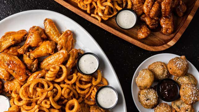 It's Just Wings food featuring chicken wings, curly fries, and dessert
