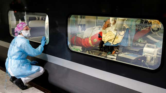 A health worker looks at a patient though the window before departure.