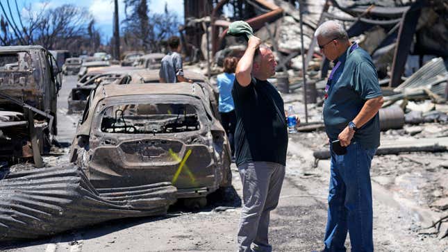 Governor of Hawaii Josh Green, left, and Maui County Mayor Richard Bissen, Jr., speak during a tour of wildfire damage on August 12, 2023, in Lahaina, Hawaii.