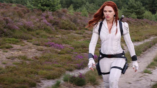 Scarlett Johansson as Natasha Romanoff in Marvel's Black Widow walking with purpose while wearing her white superhero suit.