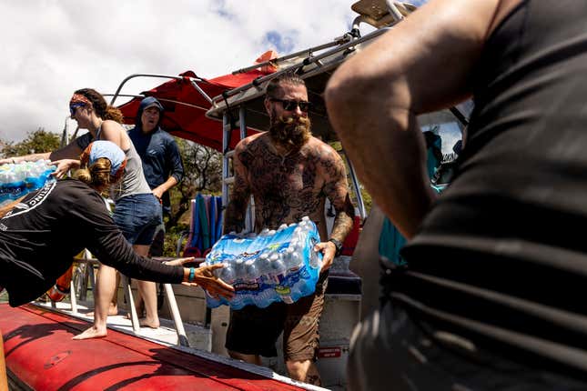 Volunteers load supplies onto a boat for West Maui at the Kihei boat landing, after a wildfire destroyed much of the historical town of Lahaina, on the island of Maui, Hawaii on August. 13, 2023.