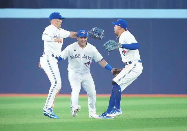 Jun 28, 2023; Toronto, Ontario, CAN; Toronto Blue Jays right fielder George Springer (4) and Toronto Blue Jays center fielder Daulton Varsho (25) and Toronto Blue Jays left fielder Whit Merrifield (15) celebrate the win against the San Francisco Giants at the end of the ninth inning at Rogers Centre.