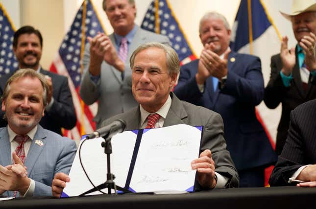 Texas Gov Greg Abbott shows off Senate Bill 1, also known as the election integrity bill, after he signed it into law in Tyler, Texas, Tuesday, Sept. 7, 2021. The sweeping bill signed Tuesday by the two-term Republican governor further tightens Texas’ strict voting laws. 