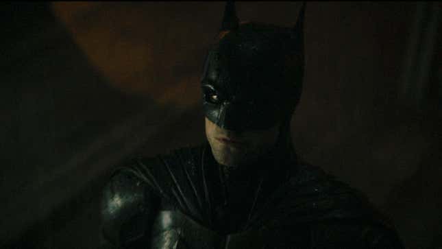 Robert Pattinson as Batman, staring up at the Bat signal. 
