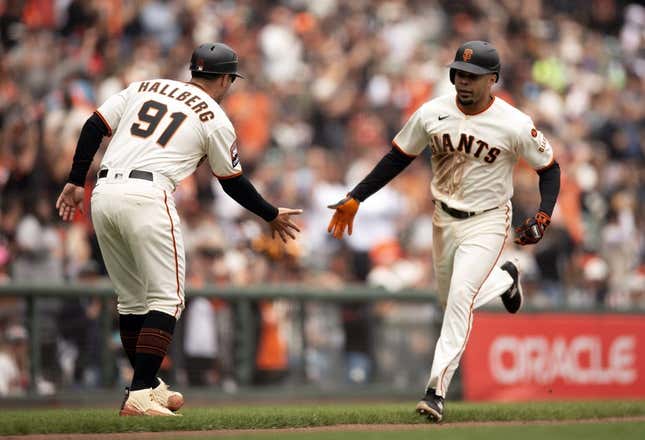 Aug 3, 2023; San Francisco, California, USA; San Francisco Giants first baseman LaMonte Wade Jr. (right) gets a congratulatory handshake from third base coach Mark Hallberg (91) after hitting a solo home run off Arizona Diamondbacks starting pitcher Brandon Pfaadt during the fourth inning at Oracle Park.