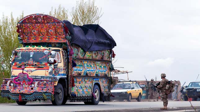 U.S. Spc. Ramiro Bojorquez watches a brightly decorated “jingle truck” pass on Highway 1 in Afghanistan's Ghazni province, April 20, 2012.